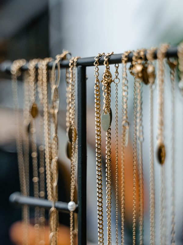 Close-up of gold necklaces displayed on a jewelry stand for elegant interior decor.